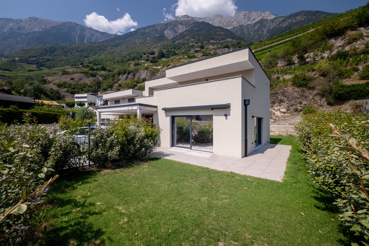 Maison contemporaine en Valais, jardin et montagnes en arrière-plan